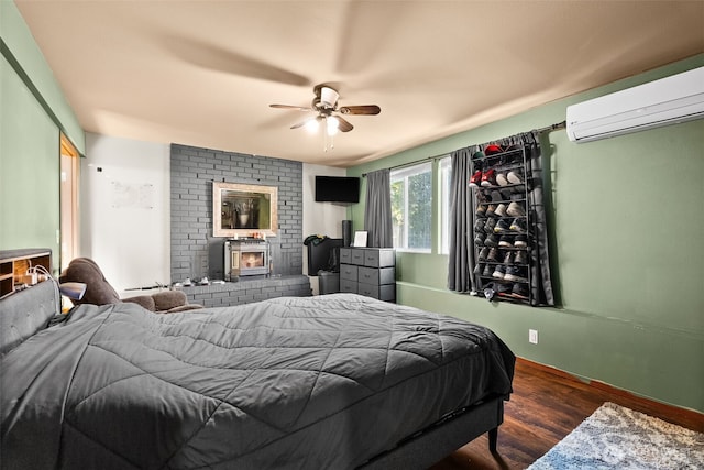 bedroom with a ceiling fan, wood finished floors, and a wall mounted AC