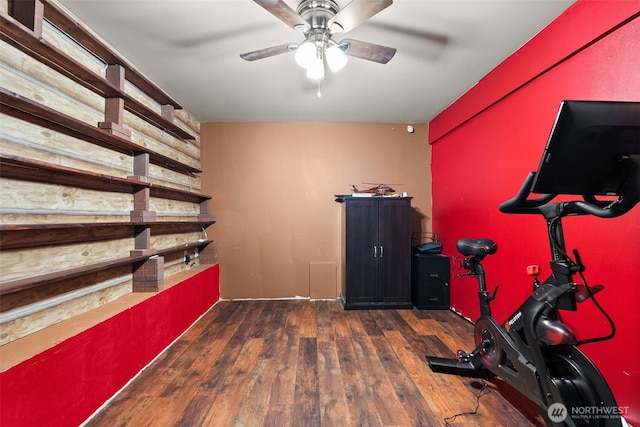 exercise area with dark wood finished floors and ceiling fan