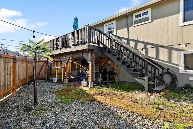 rear view of property featuring stairs and fence