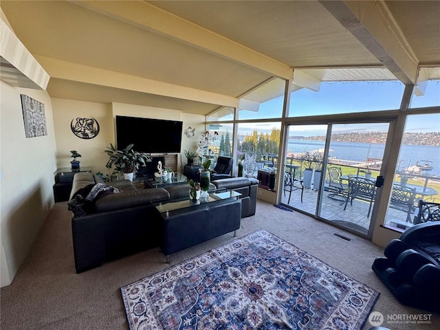 living room with lofted ceiling with beams, carpet floors, and visible vents