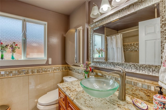 10008 Rainier Ave S, Seattle, WA 98178 - bathroom with vanity, a wainscoted wall, toilet, curtained shower, and tile walls