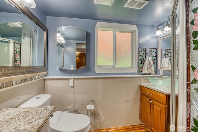 10008 Rainier Ave S, Seattle, WA 98178 - bathroom with toilet, visible vents, tile walls, and vanity