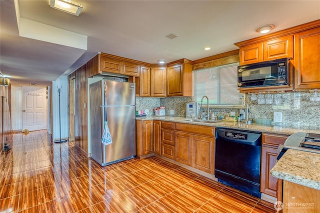 10008 Rainier Ave S, Seattle, WA 98178 - kitchen with light stone counters, black appliances, brown cabinetry, decorative backsplash, and a sink
