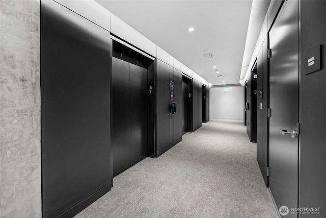 hall with recessed lighting, light carpet, and elevator