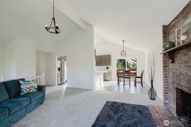 carpeted living area with high vaulted ceiling, beamed ceiling, a brick fireplace, and an inviting chandelier