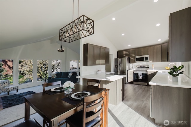 dining area featuring high vaulted ceiling, recessed lighting, and light wood-style floors