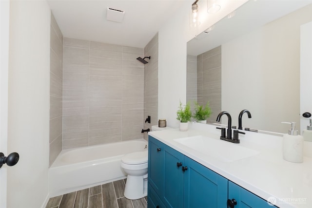 bathroom with washtub / shower combination, vanity, toilet, and wood tiled floor