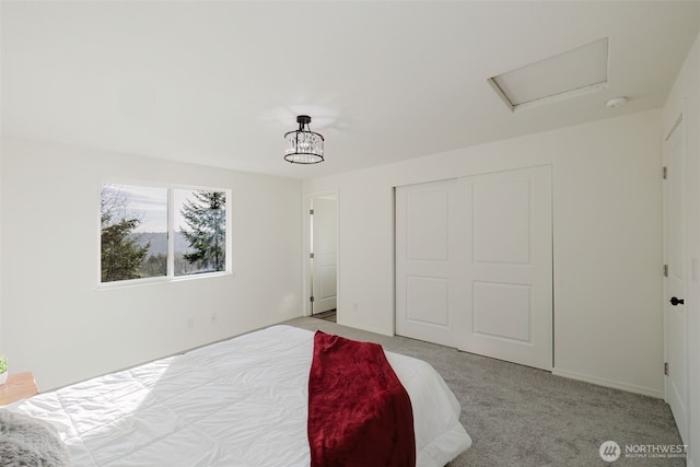 bedroom featuring attic access, a closet, and light colored carpet