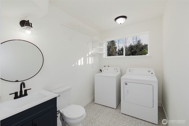 bathroom featuring washing machine and dryer, baseboards, vanity, and toilet