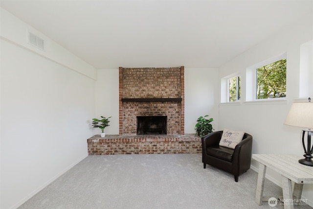 living room featuring a brick fireplace, visible vents, baseboards, and carpet flooring