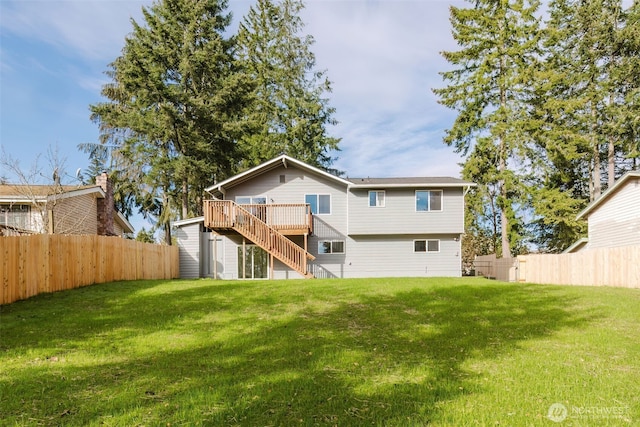 back of property featuring a fenced backyard, stairway, a lawn, and a wooden deck