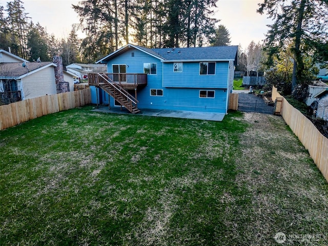 rear view of house featuring a deck, a yard, a fenced backyard, and stairs