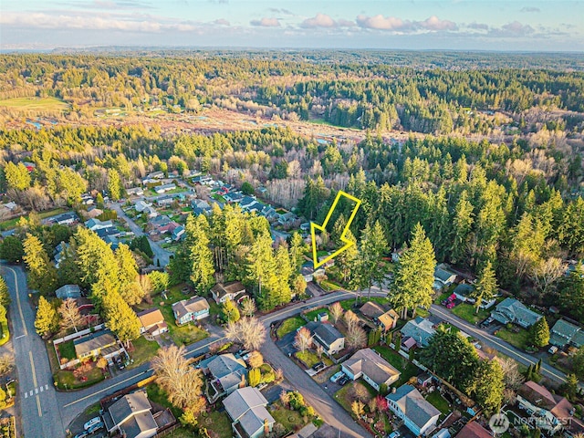 drone / aerial view featuring a residential view and a wooded view