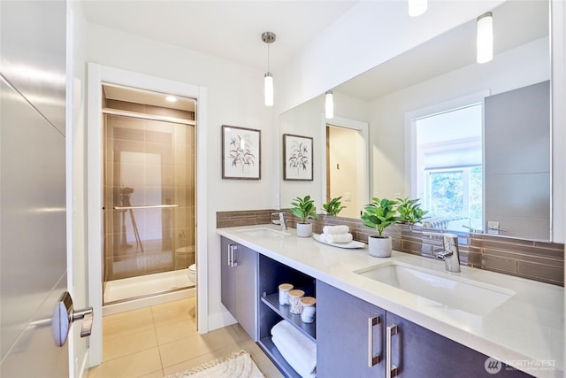 full bath with a stall shower, tile patterned flooring, and a sink