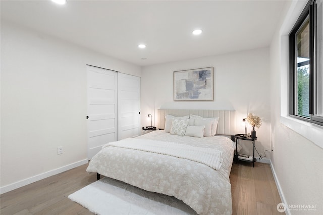 bedroom with recessed lighting, wood finished floors, and baseboards