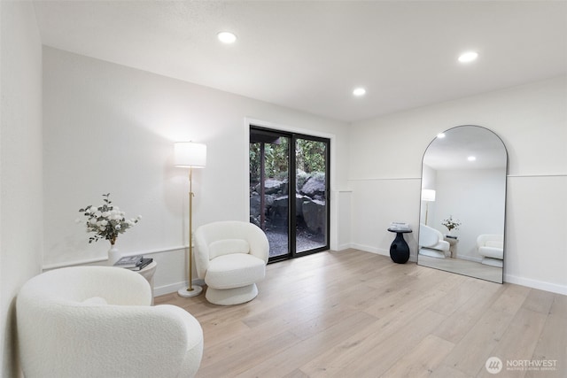 sitting room with baseboards, light wood finished floors, and recessed lighting