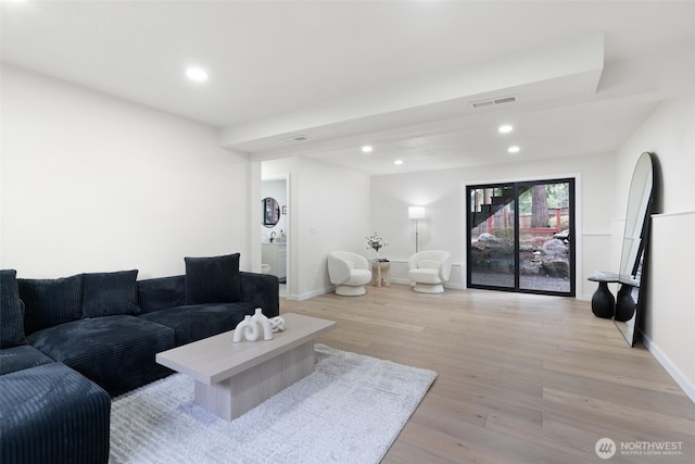 living room with light wood-style floors, baseboards, visible vents, and recessed lighting