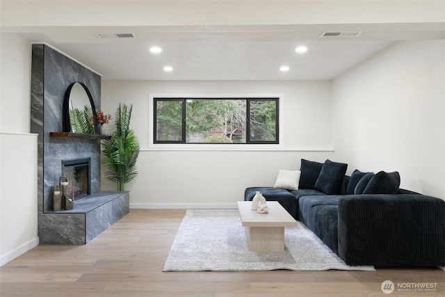 living area featuring wood finished floors, a tile fireplace, visible vents, and recessed lighting