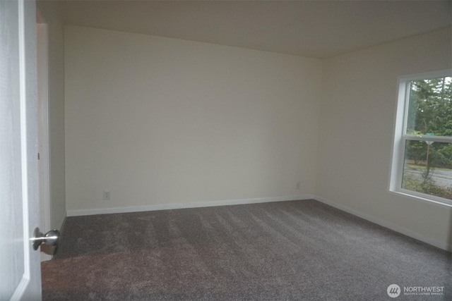 carpeted empty room featuring baseboards