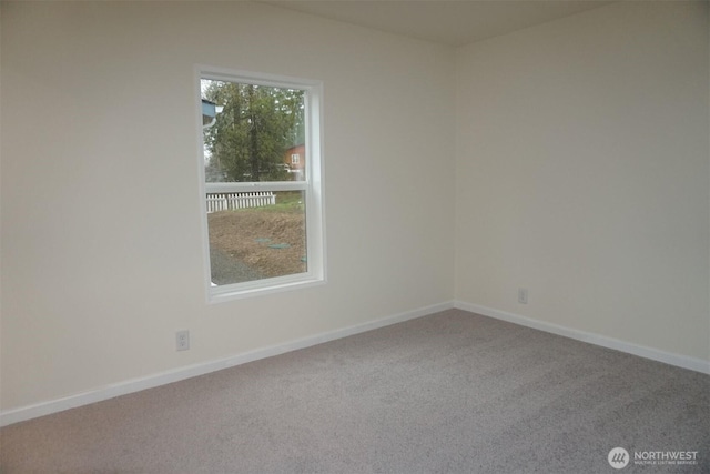 carpeted empty room featuring baseboards