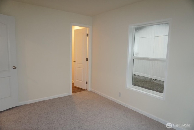 carpeted empty room with baseboards