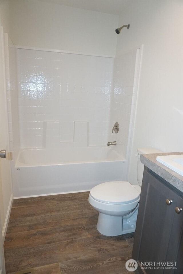 full bathroom with shower / tub combination, vanity, toilet, and wood finished floors