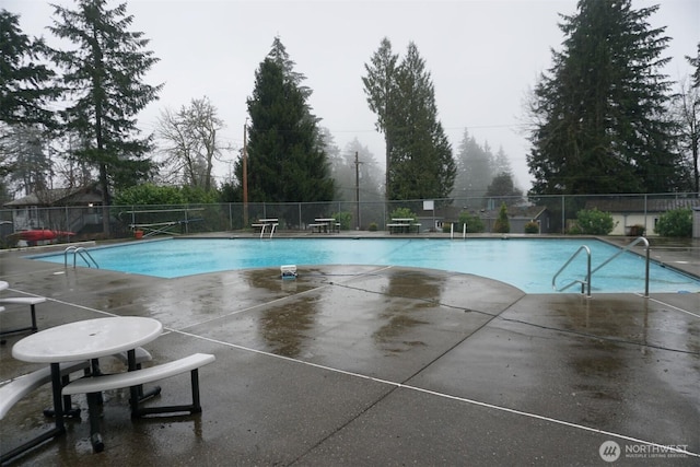 pool featuring fence and a patio