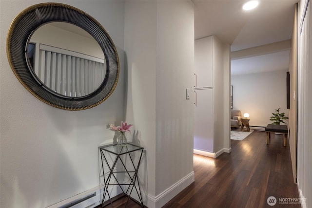 hallway with dark wood-type flooring, baseboards, and a baseboard radiator