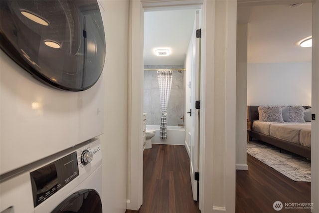 laundry room with visible vents, baseboards, stacked washer and dryer, laundry area, and dark wood-style floors