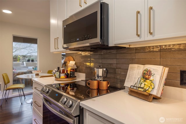 kitchen featuring stainless steel appliances, tasteful backsplash, light countertops, and white cabinetry