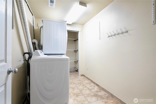 laundry room with laundry area, baseboards, visible vents, and stacked washer / drying machine