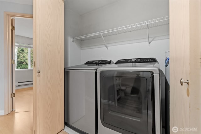 laundry area featuring laundry area, baseboard heating, and washing machine and clothes dryer