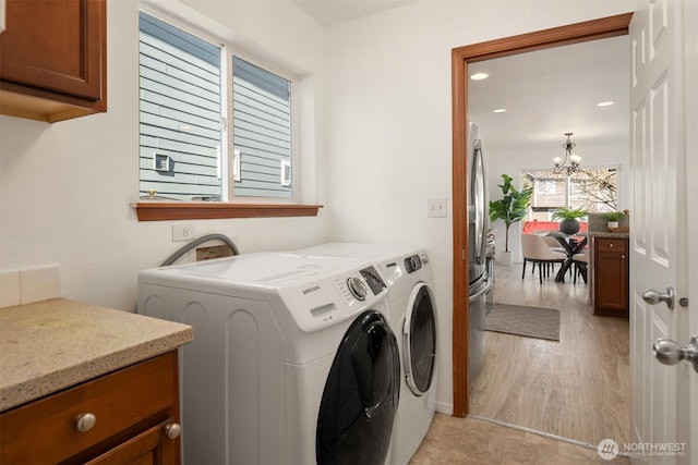 washroom with a notable chandelier, recessed lighting, cabinet space, separate washer and dryer, and light wood-type flooring