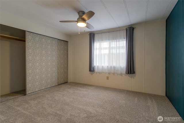 unfurnished bedroom featuring ceiling fan, a closet, and carpet flooring