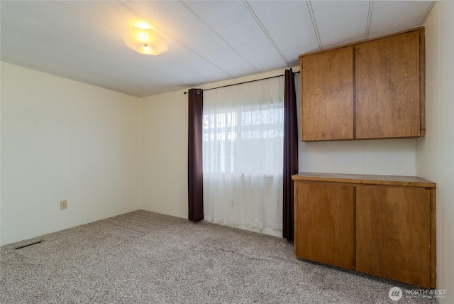 empty room with light colored carpet and visible vents