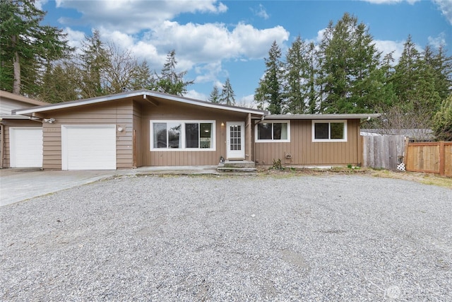 view of front of home with a garage, fence, and concrete driveway