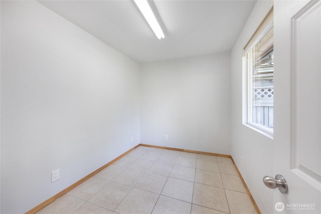 unfurnished room featuring baseboards and light tile patterned floors