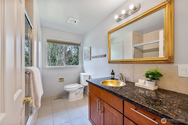 full bathroom with visible vents, decorative backsplash, tile patterned floors, a tile shower, and vanity