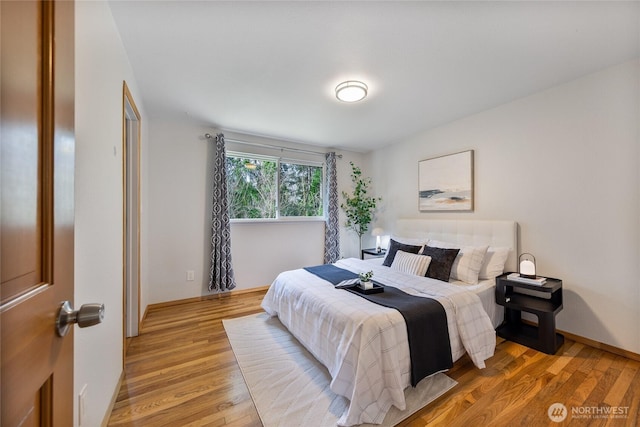 bedroom featuring baseboards and light wood finished floors