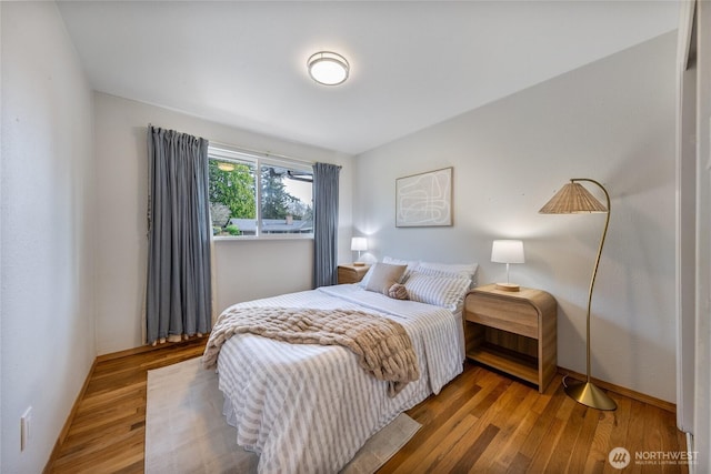 bedroom featuring wood finished floors and baseboards