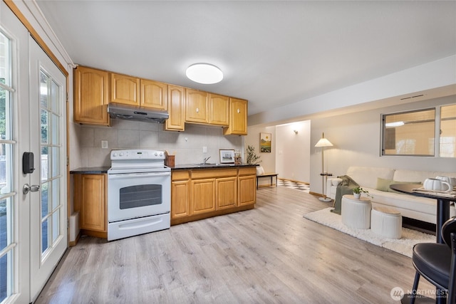 kitchen featuring white electric range oven, dark countertops, light wood-style flooring, backsplash, and under cabinet range hood