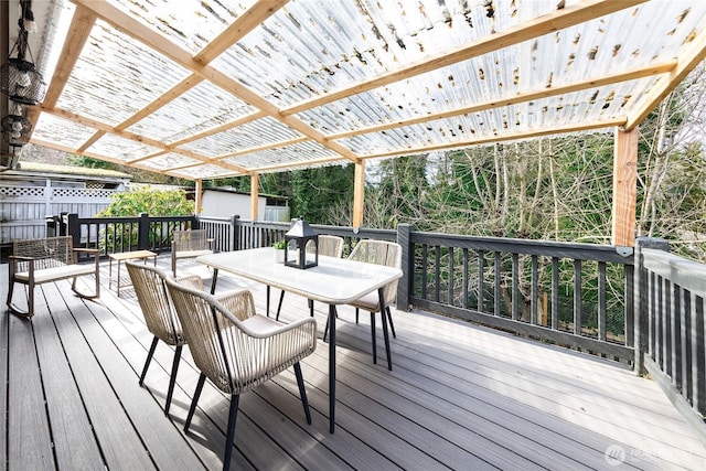 wooden deck featuring a storage shed, an outbuilding, fence, a pergola, and outdoor dining space