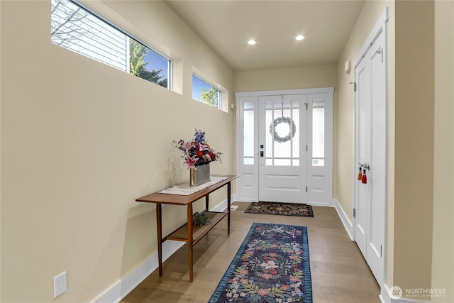 entrance foyer with baseboards, wood finished floors, and recessed lighting