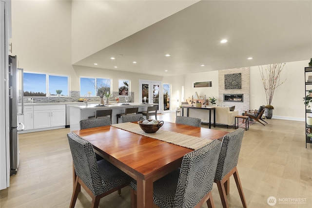 dining area featuring light wood-type flooring, a fireplace, and recessed lighting