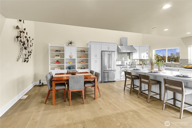 dining space with baseboards, recessed lighting, visible vents, and light wood-style floors