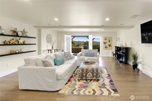 living room featuring recessed lighting, baseboards, and wood finished floors