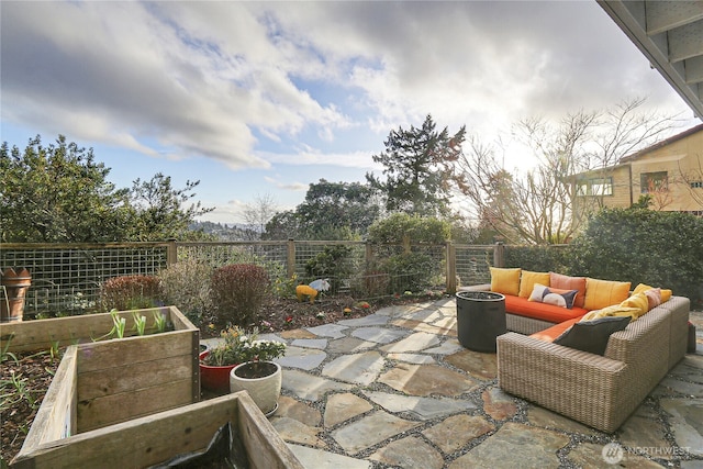 view of patio / terrace with a vegetable garden, an outdoor living space, and fence