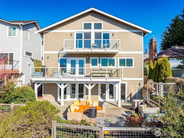 back of house with fence private yard, french doors, a patio area, and a balcony