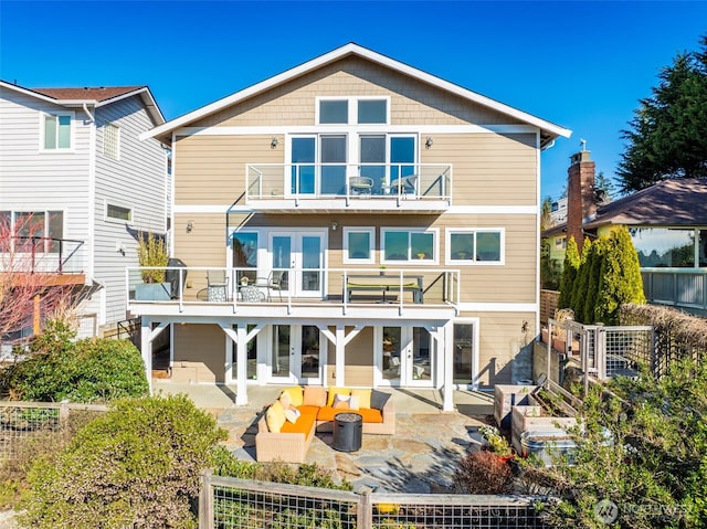 rear view of house featuring a patio, french doors, fence private yard, and a balcony