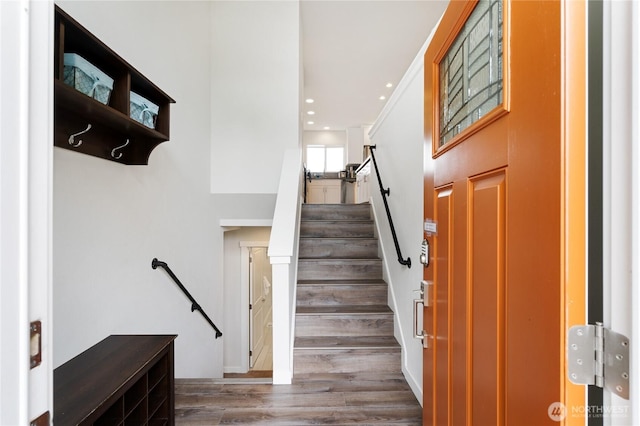 staircase with wood finished floors and recessed lighting